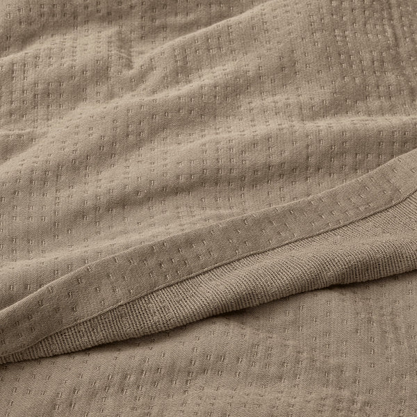 Texture Detail Of Organic Matelasse Blanket In Beige