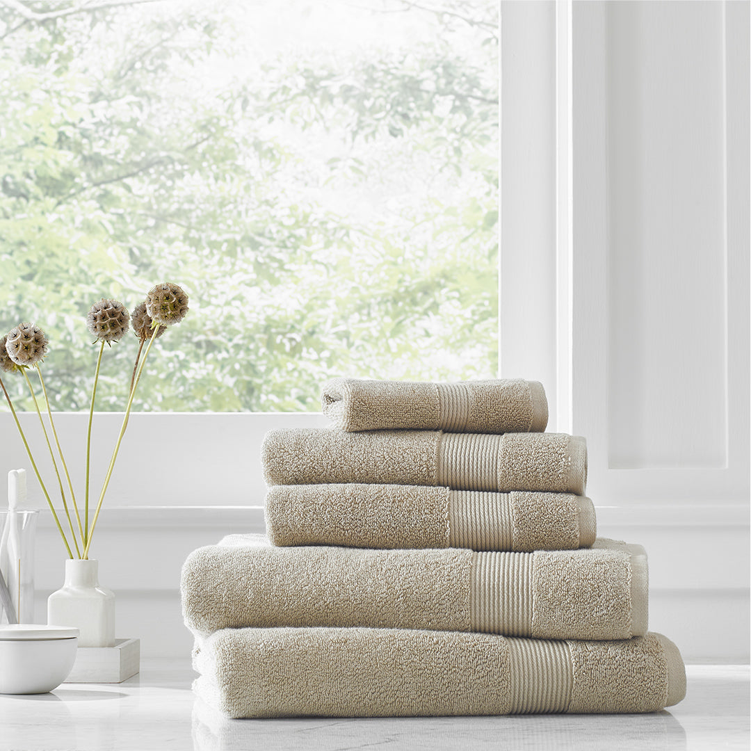 https://underthecanopy.com/cdn/shop/products/classic-organic-cotton-bath-towel-light-taupe-lifestyle_1200x.jpg?v=1684518427