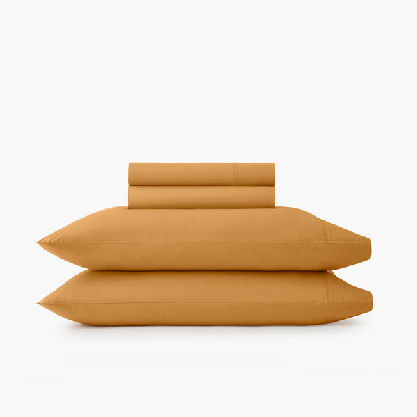 https://underthecanopy.com/cdn/shop/products/organic-cotton-percale-sheet-pillowcase-set-ochre-yellow_grande.jpg?v=1687897224