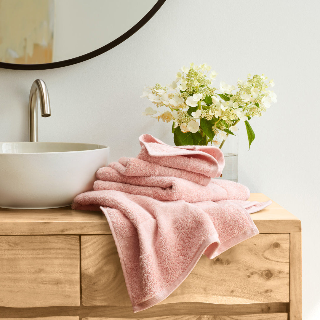 https://underthecanopy.com/cdn/shop/products/plush-organic-cotton-bath-towel-blush-pink-lifestyle_1200x.jpg?v=1687377377