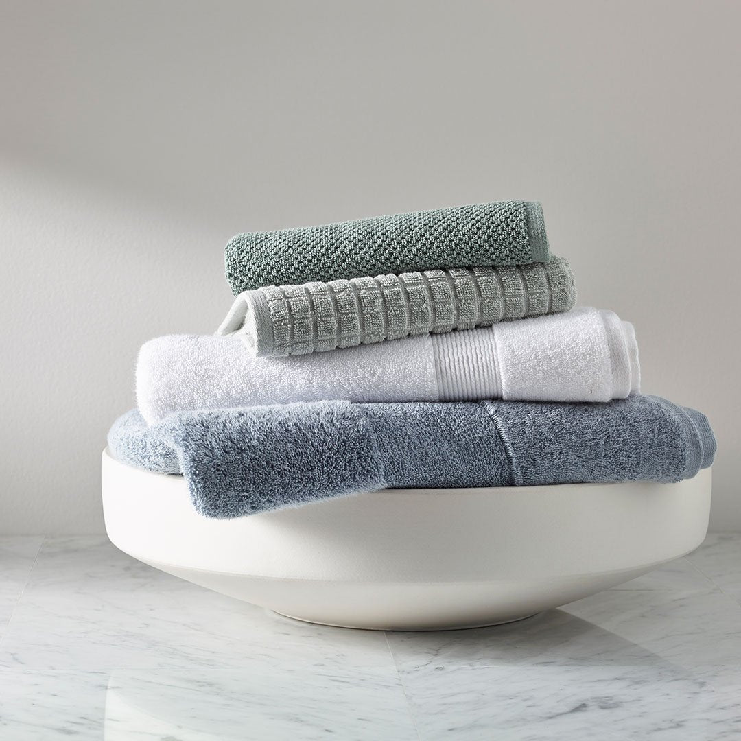 https://underthecanopy.com/cdn/shop/products/textured-organic-cotton-bath-towels-lichen-green-lifestyle-2_1200x.jpg?v=1684875775